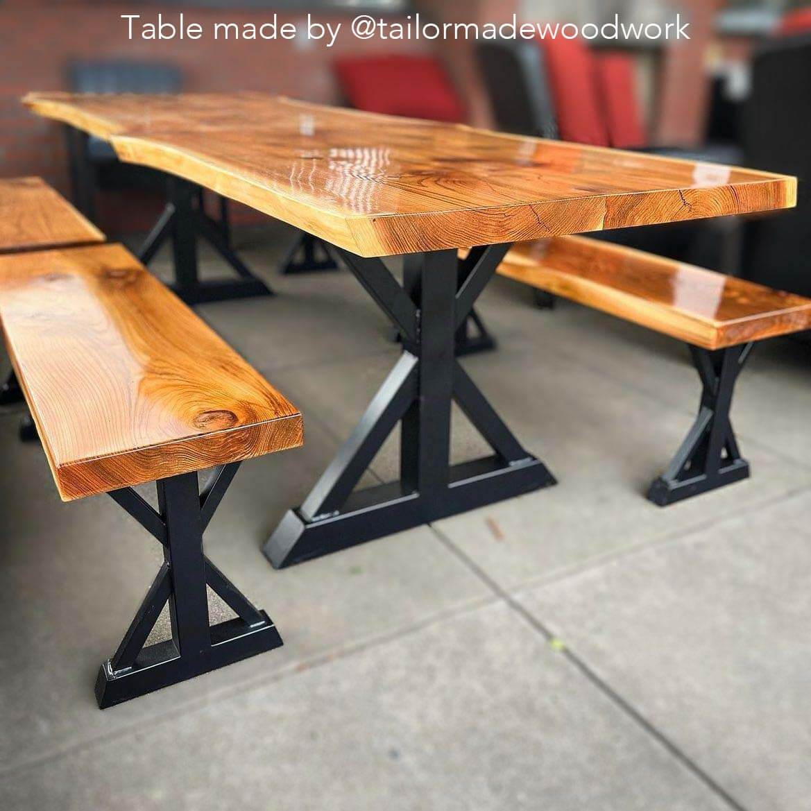 Pair of black trestle bench legs supporting a wooden table top