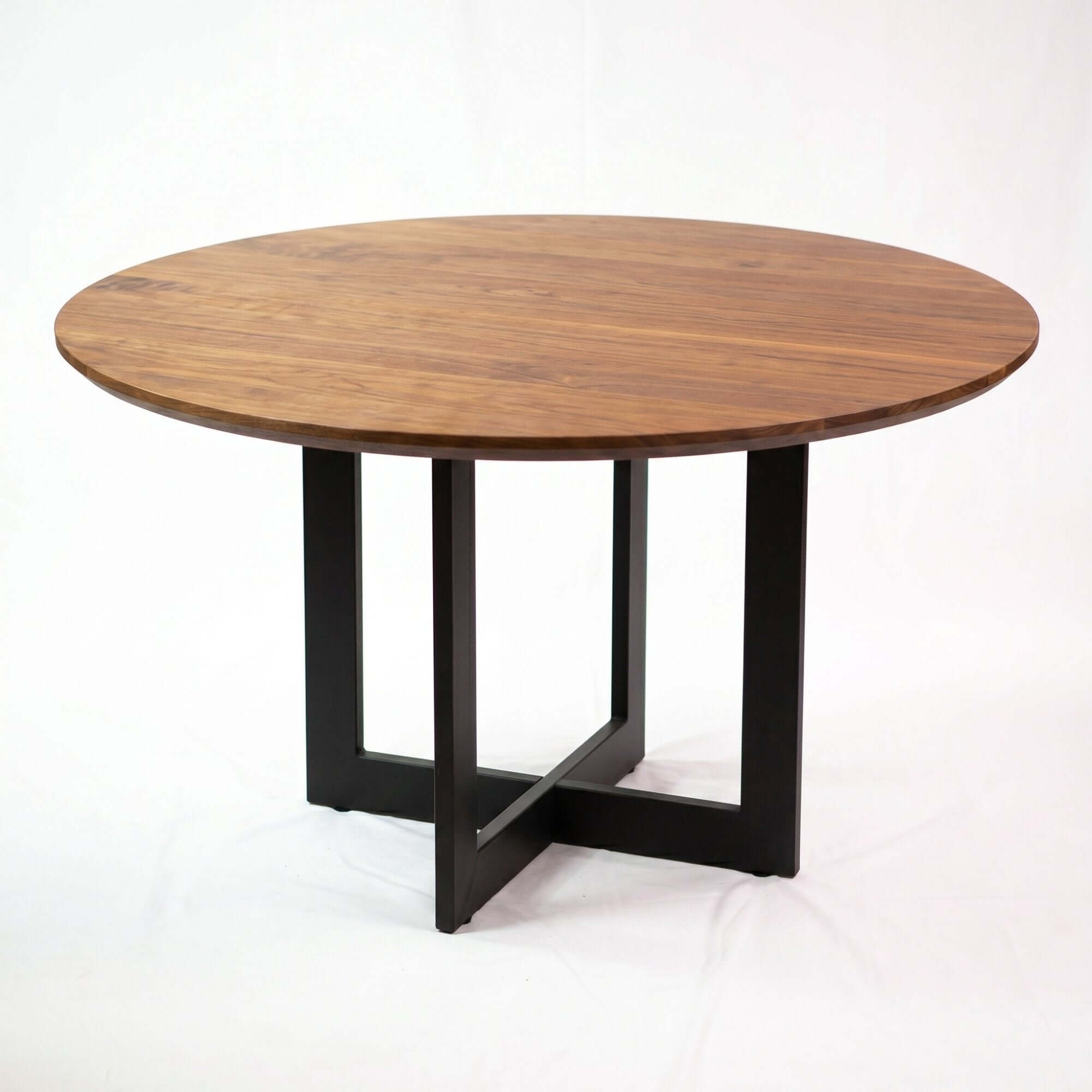 Round dining table base with dark cross legs and round wood tabletop