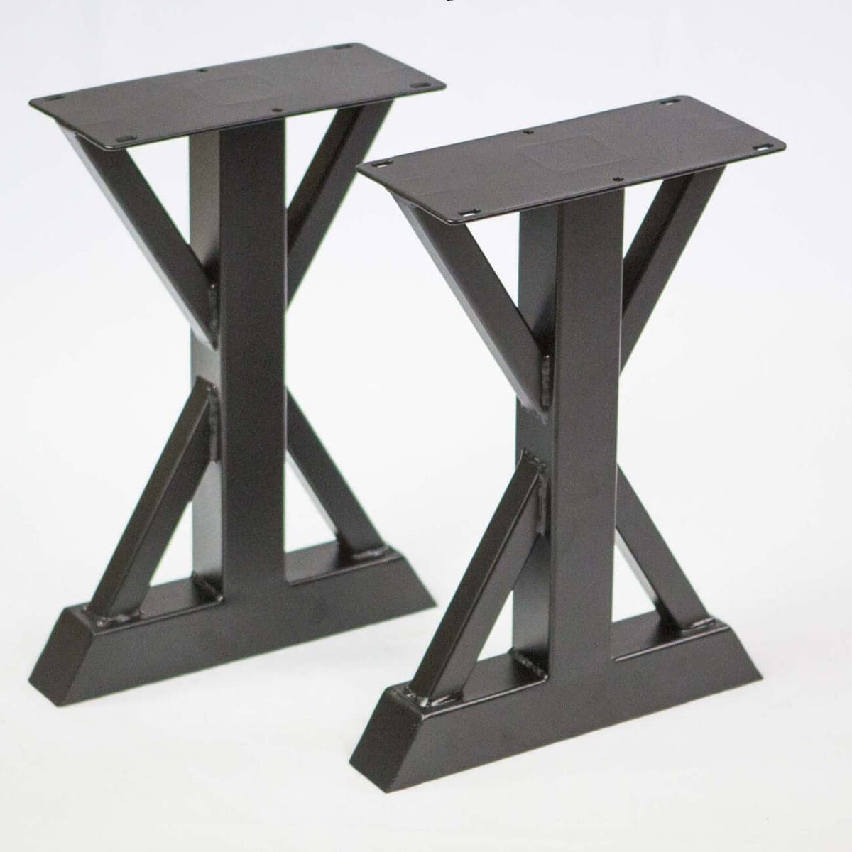 Pair of dark trestle bench legs with wide base feet and cross braces