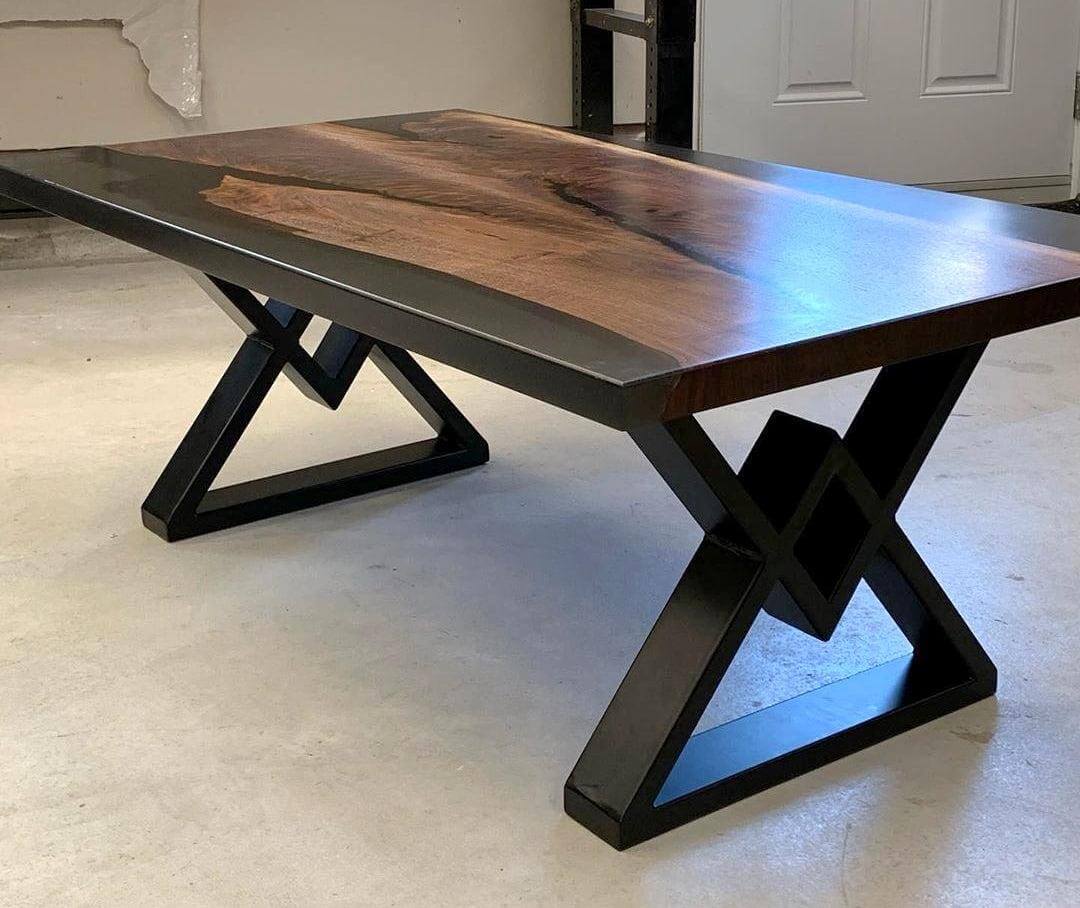 Coffee table legs with diamond-shaped dark metal base and wood top plank visible