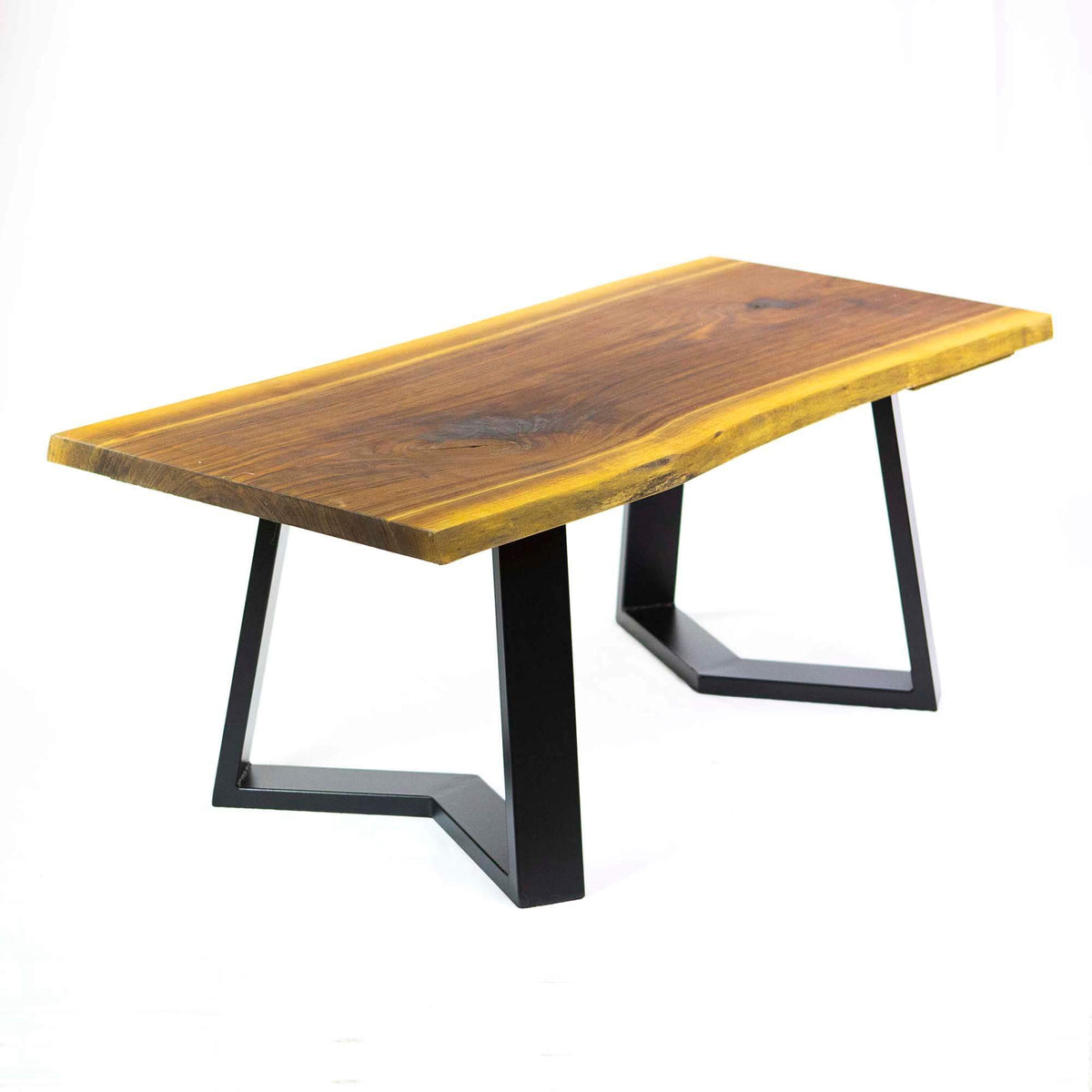 Coffee table with honey wood top and black metal legs with open rectangular bases