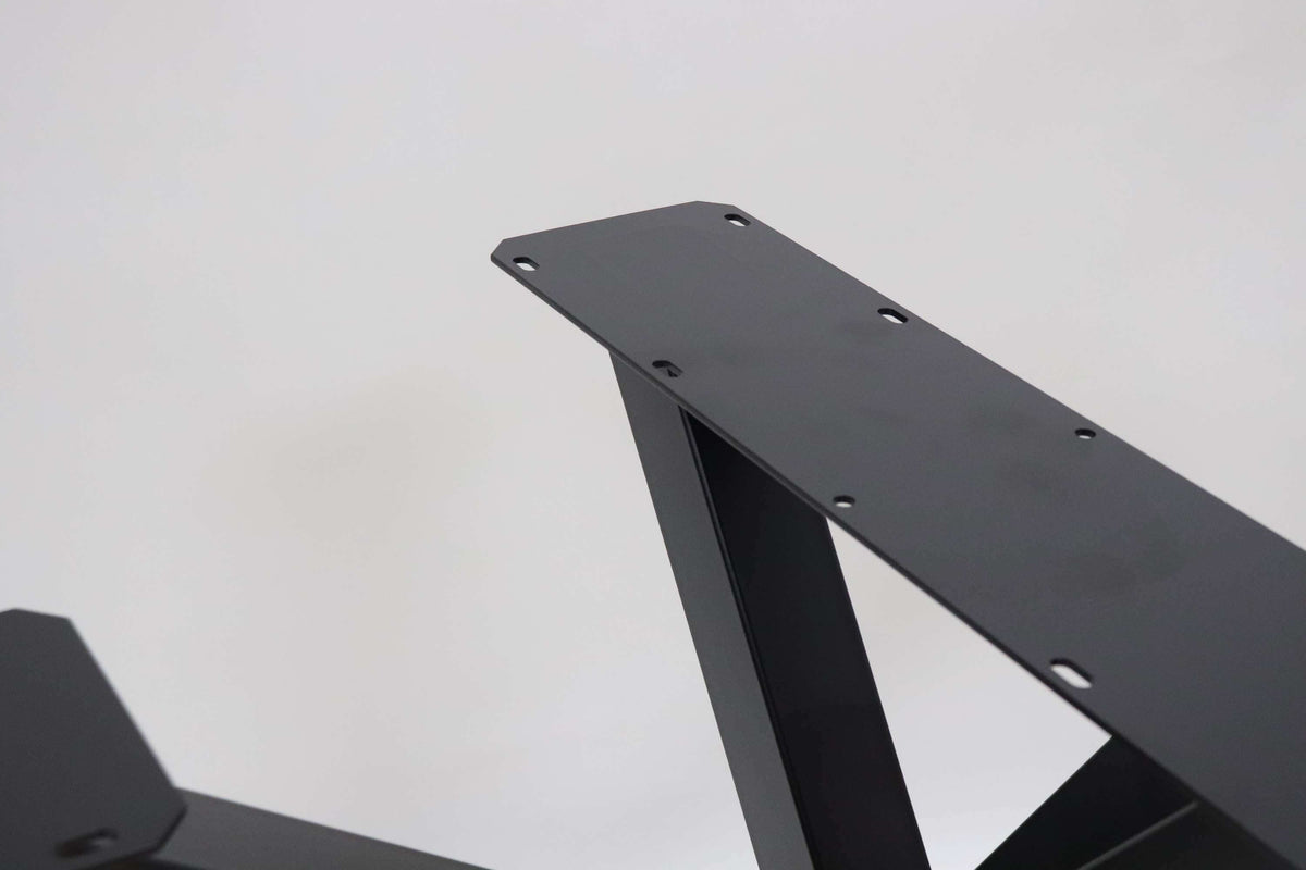 Black metal table base arm showing drilled holes on the mounting plate.