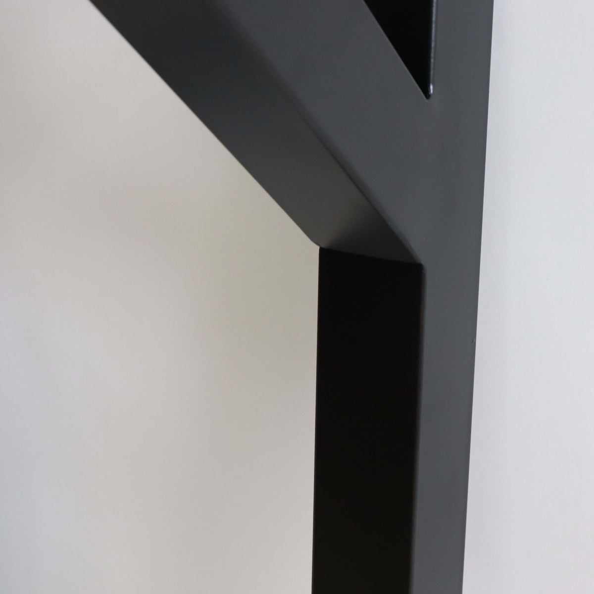 Black powder-coated Y-shaped table leg foot section with angled brace