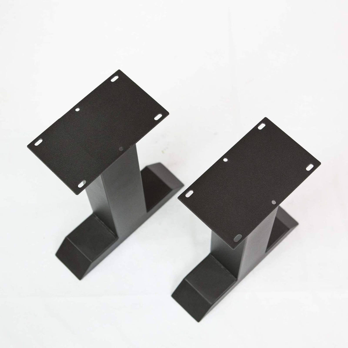Black T-shaped bench legs with steel mounting plates, bolt holes, and angled foot pads